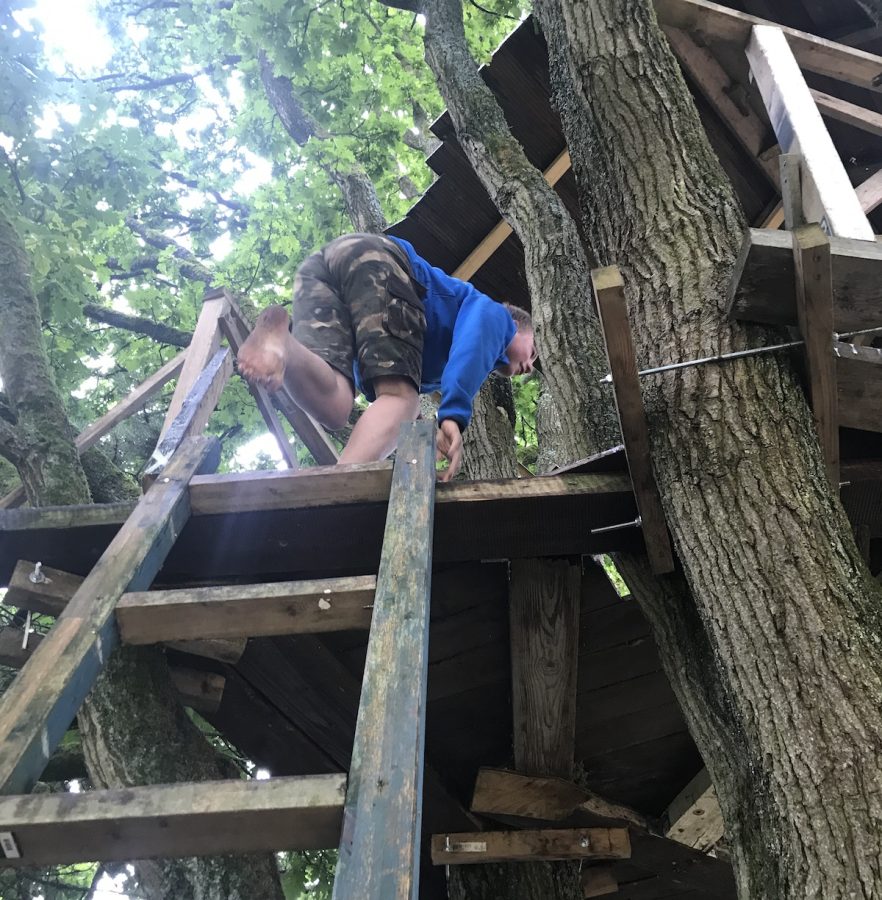 Een student klimt in een boomhut