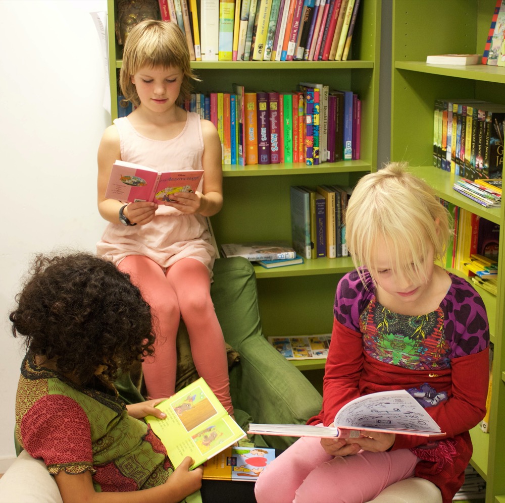 drie jonge studenten zitten bij elkaar en lezen ieder een boek