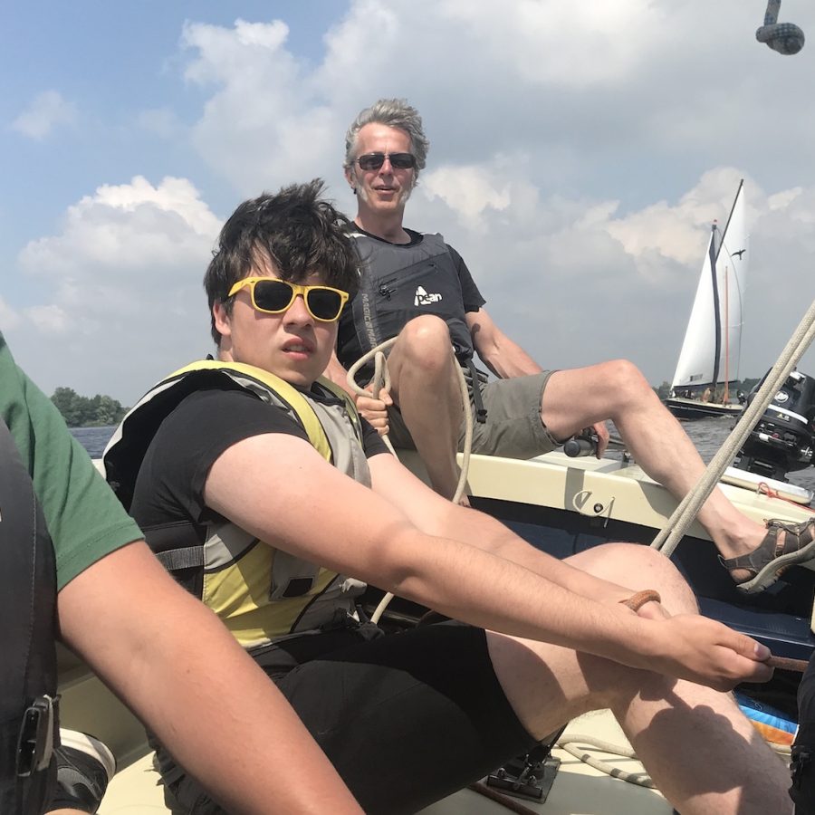 Drie studenten en een instructeur kijken vooruit, ondertussen de zeilboot laverend